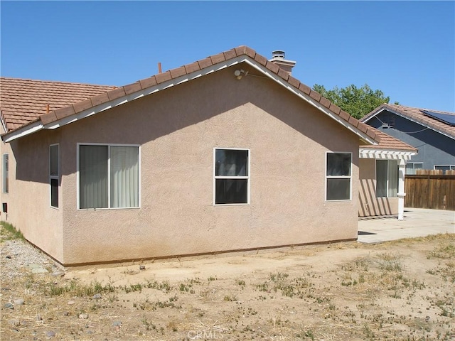 12975 Stanford Dr, Victorville, CA 92392 - view of property exterior with stucco siding, a tile roof, and a patio