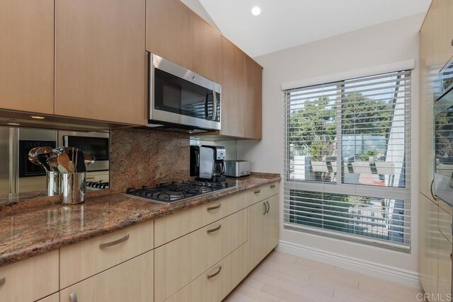12812 Caminito En Flor, Del Mar, CA 92014 - kitchen with stainless steel appliances, decorative backsplash, dark stone countertops, light wood-style flooring, and baseboards