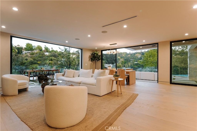 2608 Zorada Dr, Los Angeles, CA 90046 - living room with recessed lighting, light wood-style flooring, healthy amount of natural light, a wall of windows, and a chandelier