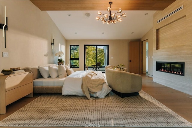 2608 Zorada Dr, Los Angeles, CA 90046 - bedroom with vaulted ceiling, wood finished floors, a chandelier, and a glass covered fireplace