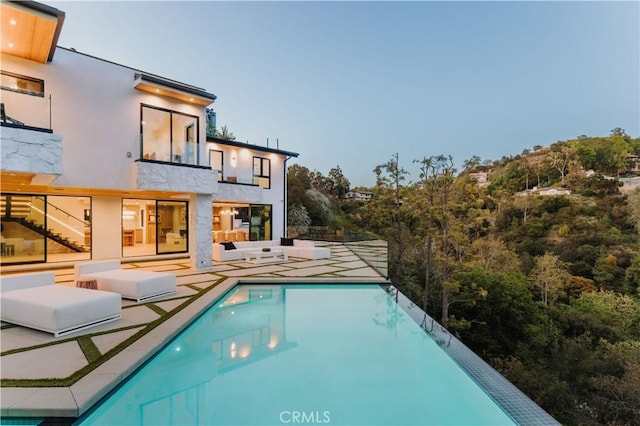2608 Zorada Dr, Los Angeles, CA 90046 - back of property with a patio area, a balcony, an infinity pool, and an outdoor hangout area