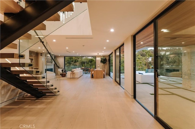 2608 Zorada Dr, Los Angeles, CA 90046 - hallway featuring a wall of windows, stairway, wood finished floors, plenty of natural light, and recessed lighting