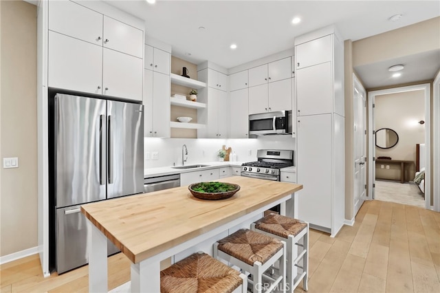 108 Coastal Gdn, Irvine, CA 92618 - kitchen with appliances with stainless steel finishes, open shelves, a sink, wood counters, and recessed lighting