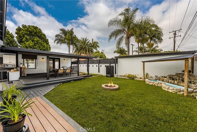 5893 E Adderley Dr, Long Beach, CA 90808 - view of grassy yard featuring an outdoor fire pit, a wooden deck, and french doors