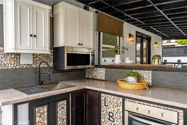 5893 E Adderley Dr, Long Beach, CA 90808 - kitchen featuring stainless steel appliances, a sink, tasteful backsplash, white cabinets, and light countertops