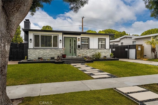 5893 E Adderley Dr, Long Beach, CA 90808 - view of front of home with stone siding, a chimney, a gate, and driveway