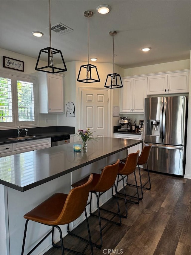 31827 Ives Ct, Menifee, CA 92584 - kitchen with stainless steel appliances, a sink, dark countertops, white cabinets, and recessed lighting
