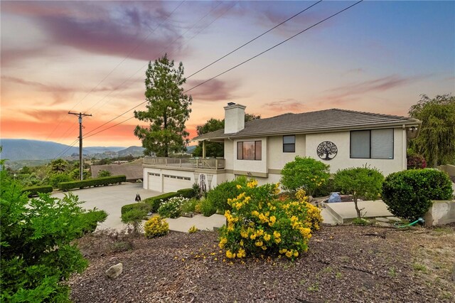 1357 Sunny Heights Rd, Fallbrook, CA 92028 - view of front facade with a chimney, driveway, a mountain view, stucco siding, and a balcony