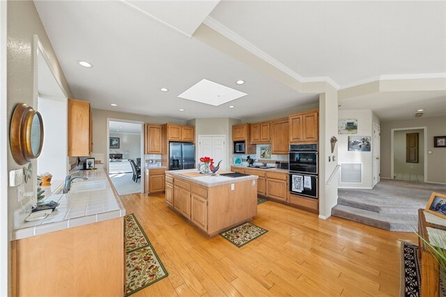 1357 Sunny Heights Rd, Fallbrook, CA 92028 - kitchen featuring refrigerator with ice dispenser, tile counters, a skylight, a center island, and a sink