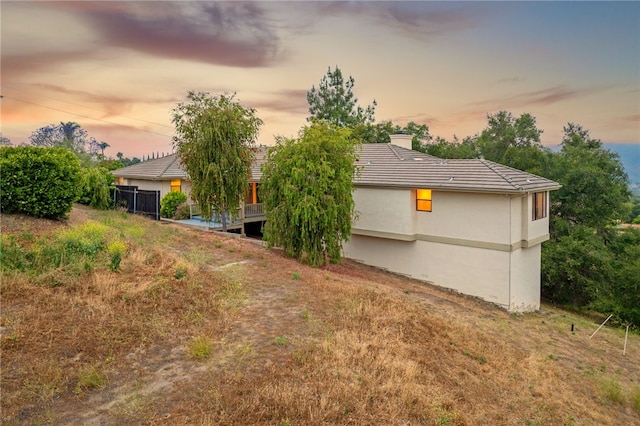 1357 Sunny Heights Rd, Fallbrook, CA 92028 - back of property at dusk with a chimney, a tiled roof, and stucco siding