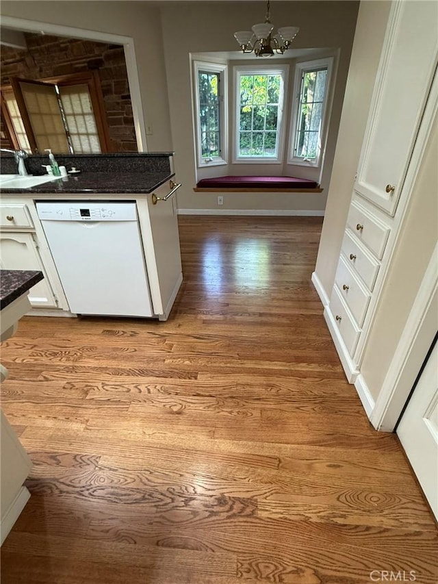 117 S Park Dr, Madera, CA 93637 - kitchen featuring white dishwasher, white cabinets, a chandelier, and light wood-style floors