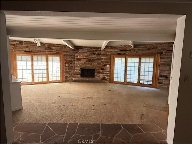 117 S Park Dr, Madera, CA 93637 - unfurnished living room with carpet floors, beam ceiling, healthy amount of natural light, and a stone fireplace