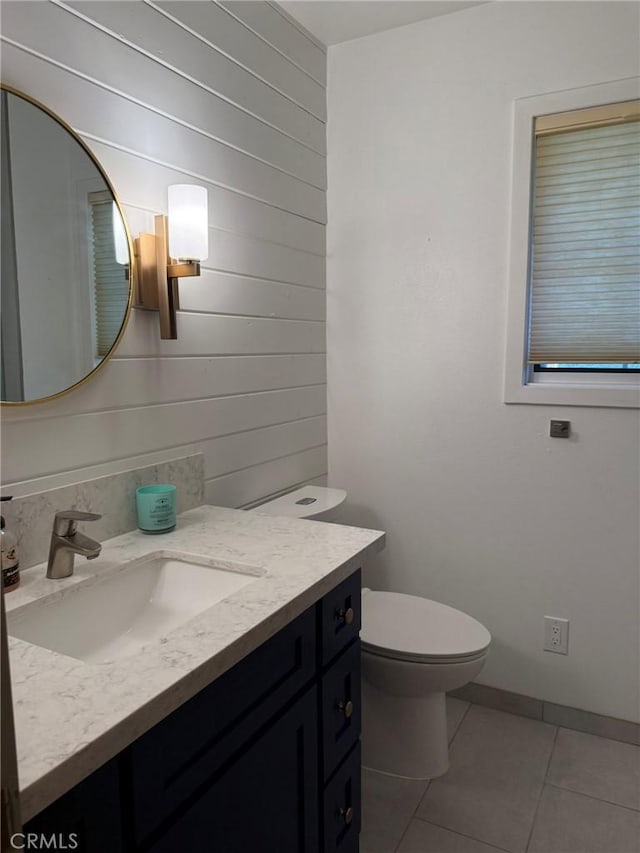 117 S Park Dr, Madera, CA 93637 - half bathroom featuring vanity, tile patterned floors, toilet, and wooden walls