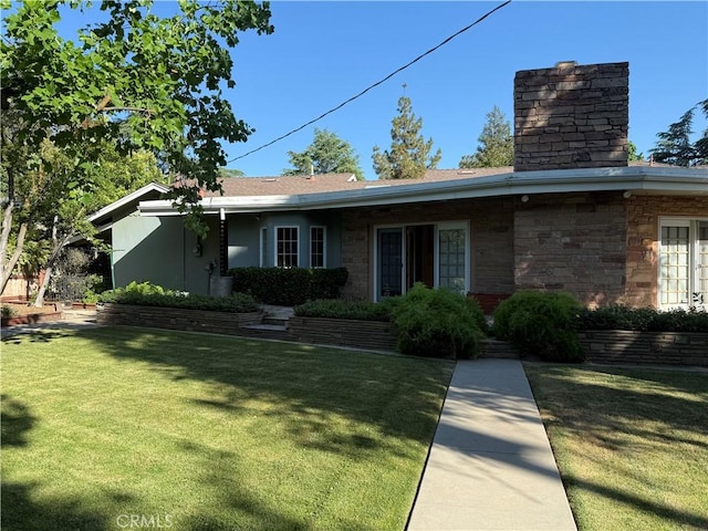 117 S Park Dr, Madera, CA 93637 - view of front facade featuring a chimney, a front yard, and stone siding