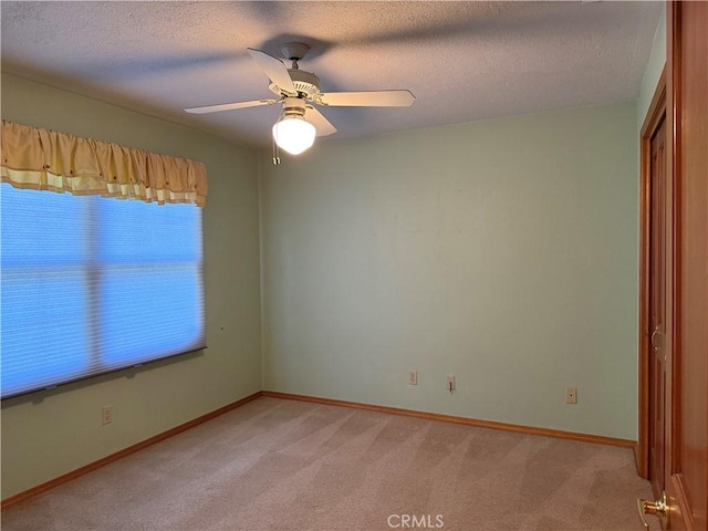117 S Park Dr, Madera, CA 93637 - spare room with light carpet, a ceiling fan, baseboards, and a textured ceiling