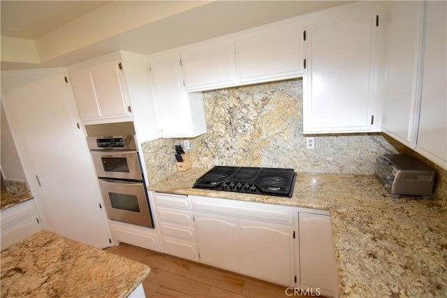 14279 Galleon Ln, Helendale, CA 92342 - kitchen with black gas cooktop, stainless steel double oven, decorative backsplash, and white cabinets