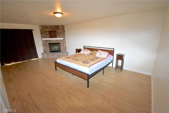 14279 Galleon Ln, Helendale, CA 92342 - bedroom featuring light wood finished floors, baseboards, and a fireplace