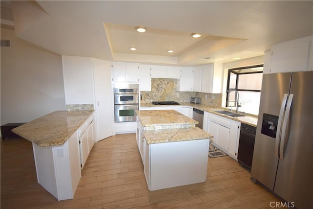 14279 Galleon Ln, Helendale, CA 92342 - kitchen with appliances with stainless steel finishes, a peninsula, a sink, a kitchen island, and tasteful backsplash