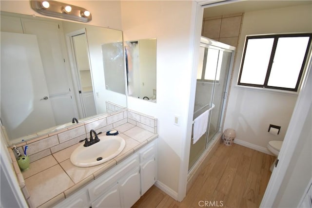 14279 Galleon Ln, Helendale, CA 92342 - bathroom featuring wood finished floors, vanity, a stall shower, baseboards, and toilet