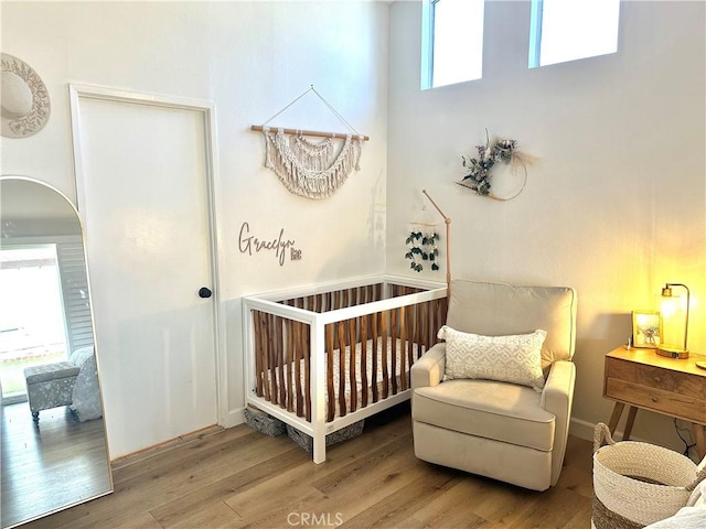 140 W Pioneer Ave Unit 52, Redlands, CA 92374 - bedroom featuring a crib, wood finished floors, and arched walkways
