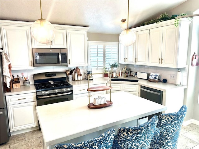 140 W Pioneer Ave Unit 52, Redlands, CA 92374 - kitchen with stainless steel appliances, light countertops, pendant lighting, white cabinetry, and a sink