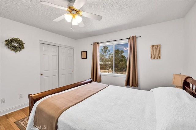 6279 Baileya Ave Unit 29, Palms, CA 92277 - bedroom featuring light wood-style flooring, a textured ceiling, a closet, a ceiling fan, and baseboards