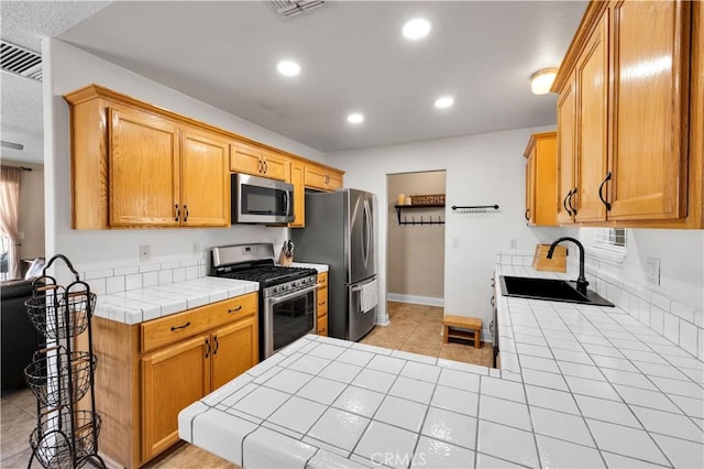 6279 Baileya Ave Unit 29, Palms, CA 92277 - kitchen with stainless steel appliances, tile countertops, a sink, recessed lighting, and light tile patterned floors