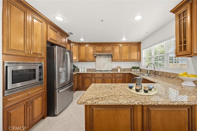 4937 Peck Rd Unit C, El Monte, CA 91732 - kitchen featuring appliances with stainless steel finishes, a sink, brown cabinets, a peninsula, and light stone countertops