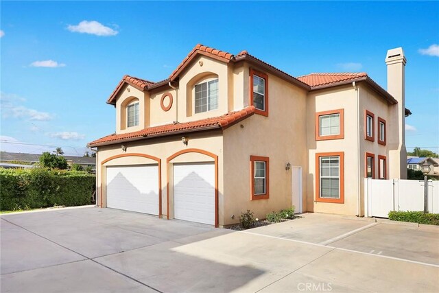 4937 Peck Rd Unit C, El Monte, CA 91732 - mediterranean / spanish-style home with an attached garage, concrete driveway, stucco siding, and a tile roof
