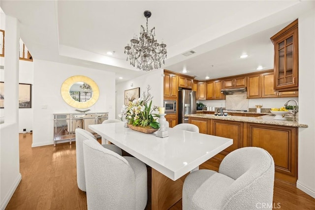 4937 Peck Rd Unit C, El Monte, CA 91732 - kitchen with stainless steel appliances, under cabinet range hood, recessed lighting, brown cabinetry, and baseboards