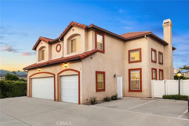4937 Peck Rd Unit C, El Monte, CA 91732 - mediterranean / spanish house with an attached garage, a chimney, stucco siding, concrete driveway, and a tile roof