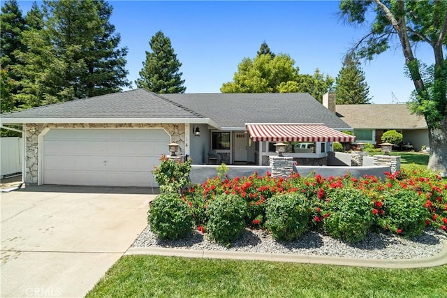 3014 California Park Dr, Chico, CA 95928 - view of front of property with stone siding, an attached garage, driveway, a shingled roof, and a chimney