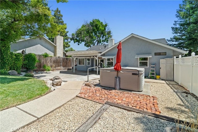 3014 California Park Dr, Chico, CA 95928 - back of property featuring a hot tub, a patio, a fenced backyard, and stucco siding