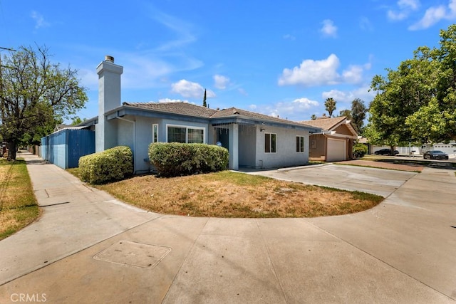 7701 Baird Ave, Reseda, CA 91335 - view of front facade with a garage, concrete driveway, a chimney, and stucco siding