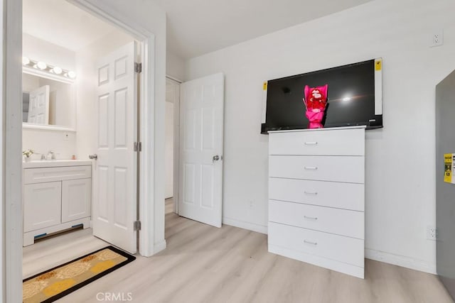 7701 Baird Ave, Reseda, CA 91335 - bedroom featuring light wood finished floors, a sink, baseboards, and ensuite bathroom