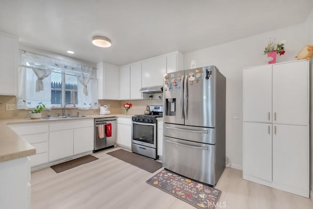 7701 Baird Ave, Reseda, CA 91335 - kitchen with appliances with stainless steel finishes, ventilation hood, a sink, light wood-style flooring, and light countertops