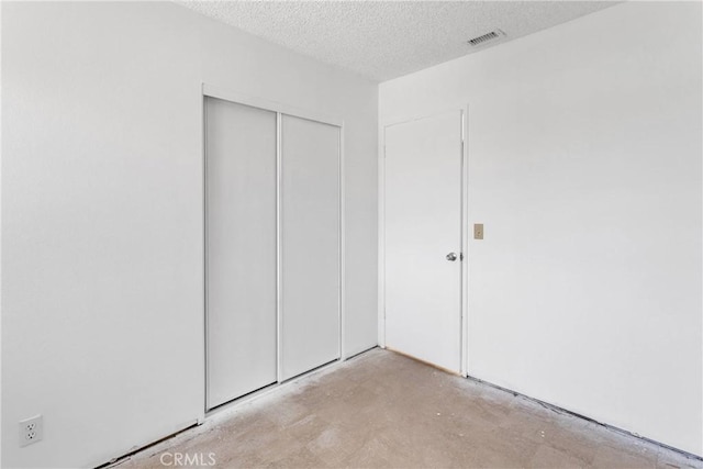 9820 Mandalay Ct, Riverside, CA 92503 - unfurnished bedroom with unfinished concrete floors, a closet, and a textured ceiling