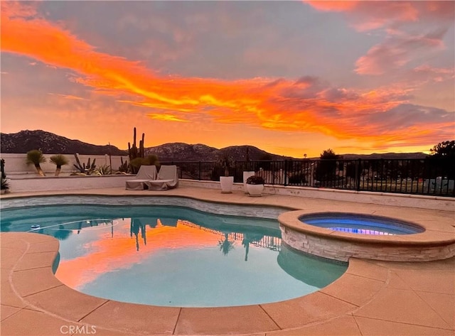 32070 Corte Bonilio, Temecula, CA 92592 - pool at dusk featuring a fenced backyard, a mountain view, a pool with connected hot tub, and a patio