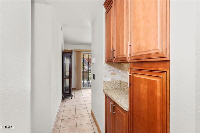 849 Plaza Cuernavaca Way, San Diego, CA 92114 - kitchen with light tile patterned flooring, light stone counters, decorative backsplash, and brown cabinetry