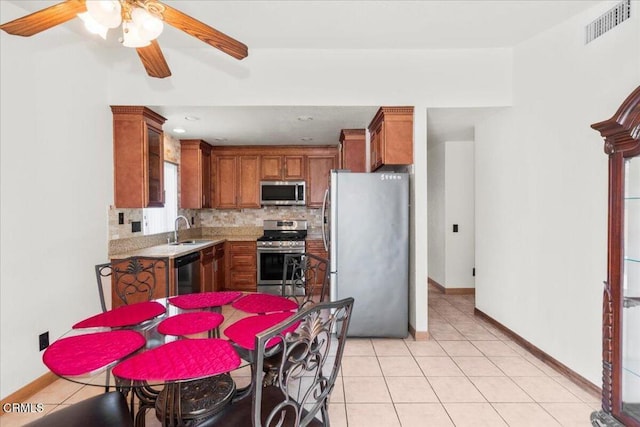 849 Plaza Cuernavaca Way, San Diego, CA 92114 - kitchen with appliances with stainless steel finishes, brown cabinets, light countertops, backsplash, and ceiling fan