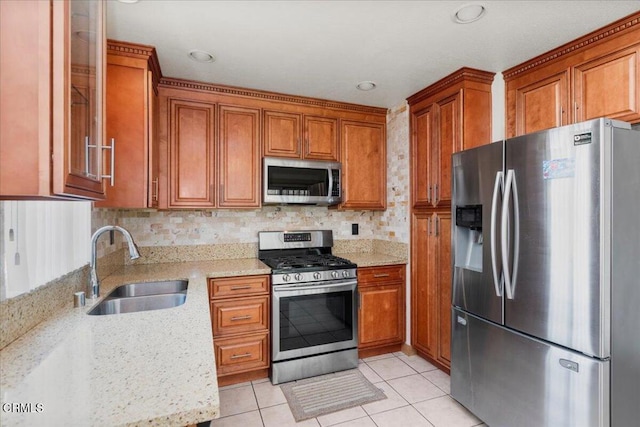 849 Plaza Cuernavaca Way, San Diego, CA 92114 - kitchen with stainless steel appliances, brown cabinets, light tile patterned floors, light stone counters, and recessed lighting