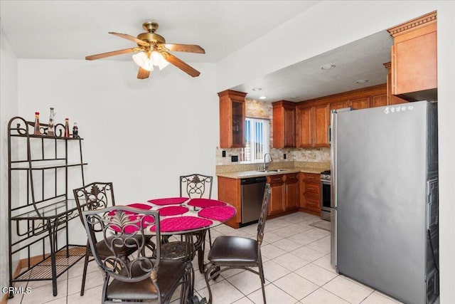 849 Plaza Cuernavaca Way, San Diego, CA 92114 - kitchen featuring stainless steel appliances, brown cabinetry, light countertops, ceiling fan, and light tile patterned flooring