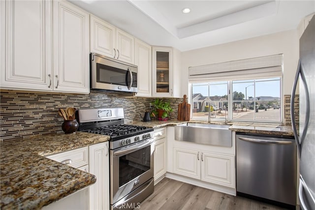 28162 Bavaria Dr, Menifee, CA 92585 - kitchen featuring stainless steel appliances, a sink, decorative backsplash, glass insert cabinets, and recessed lighting