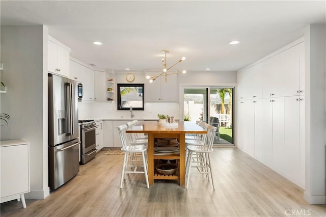 33252 Big Sur St, Dana Point, CA 92629 - kitchen with stainless steel appliances, open shelves, light countertops, light wood finished floors, and white cabinetry