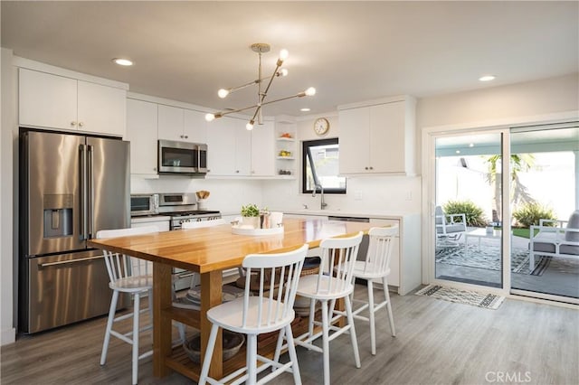 33252 Big Sur St, Dana Point, CA 92629 - kitchen with stainless steel appliances, a kitchen bar, wood finished floors, a center island, and recessed lighting