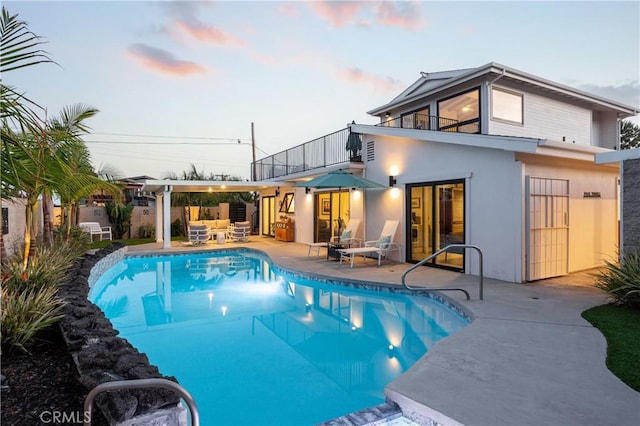 33252 Big Sur St, Dana Point, CA 92629 - back of house at dusk featuring a balcony, an outdoor living space, stucco siding, and a patio area