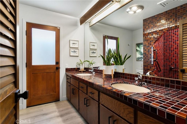 33252 Big Sur St, Dana Point, CA 92629 - full bath with double vanity, wood finished floors, beam ceiling, and backsplash