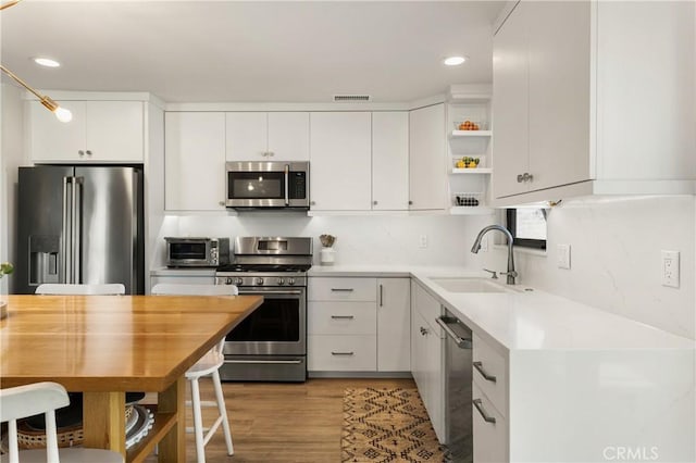 33252 Big Sur St, Dana Point, CA 92629 - kitchen with appliances with stainless steel finishes, open shelves, white cabinets, recessed lighting, and light wood finished floors