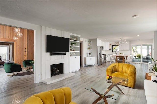 33252 Big Sur St, Dana Point, CA 92629 - living area with a chandelier, light wood-type flooring, a large fireplace, and recessed lighting