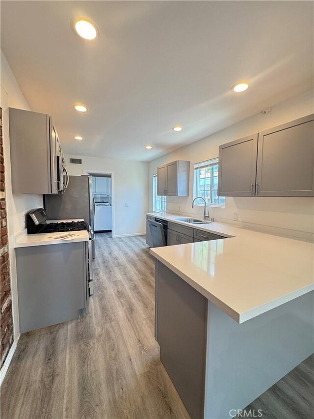 23308 Friar St, Woodland Hills, CA 91367 - kitchen featuring gray cabinets, range with gas stovetop, stainless steel microwave, light wood-type flooring, and recessed lighting